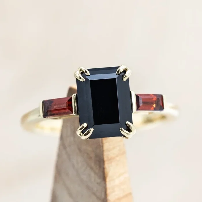 “ALBINA” – EMERALD CUT BLACK ONYX ENGAGEMENT RING WITH DOUBLE CLAW PRONGS AND MOZAMBIQUE GARNET ACCENTS