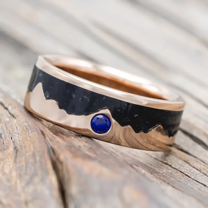 “HELIOS” – JET STONE & GOLD MOUNTAIN RANGE WEDDING RING FEATURING A LAB-GROWN BLUE SAPPHIRE ACCENT