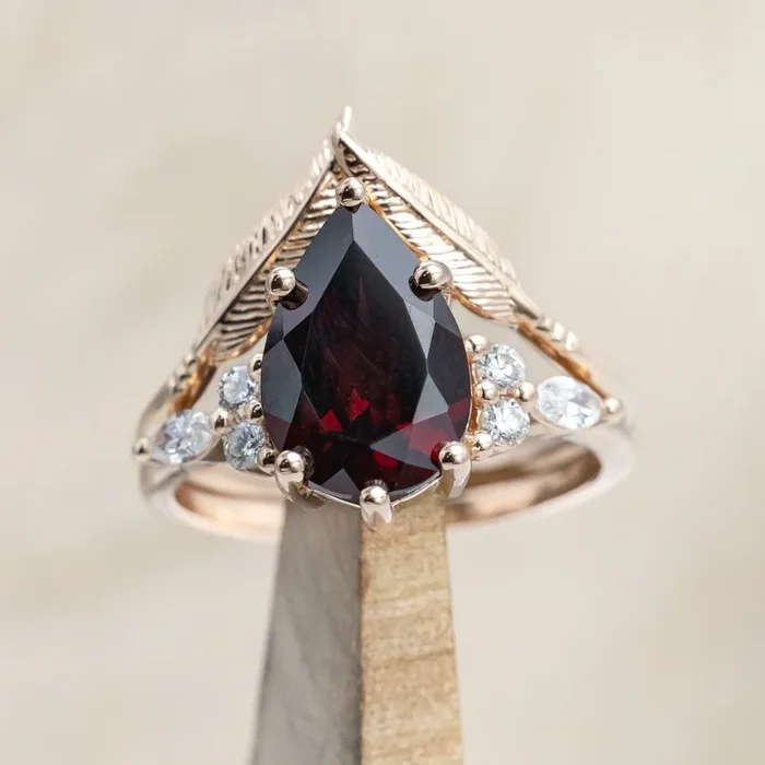 “SAGE” – PEAR CUT MOZAMBIQUE GARNET ENGAGEMENT RING WITH DIAMOND ACCENTS & “FALA” TRACER
